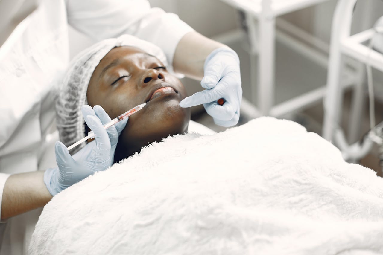 A woman receiving a cosmetic injection with syringe in a medical setting.